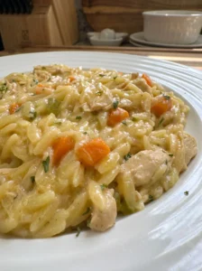 Close-up of creamy chicken pot pie orzo served on a white plate