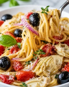 A bowl of flavorful Mediterranean One Pot Pasta with olives, artichokes, and tomatoes.