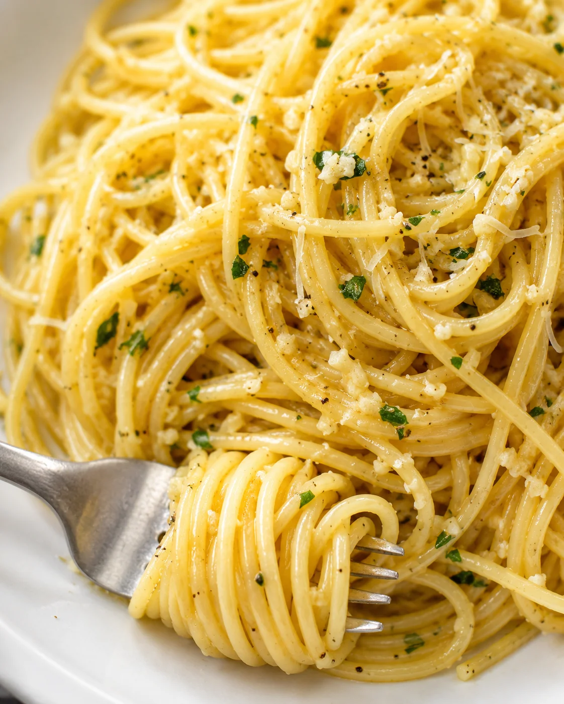 Close-up of creamy garlic butter noodles garnished with parsley and Parmesan cheese.
