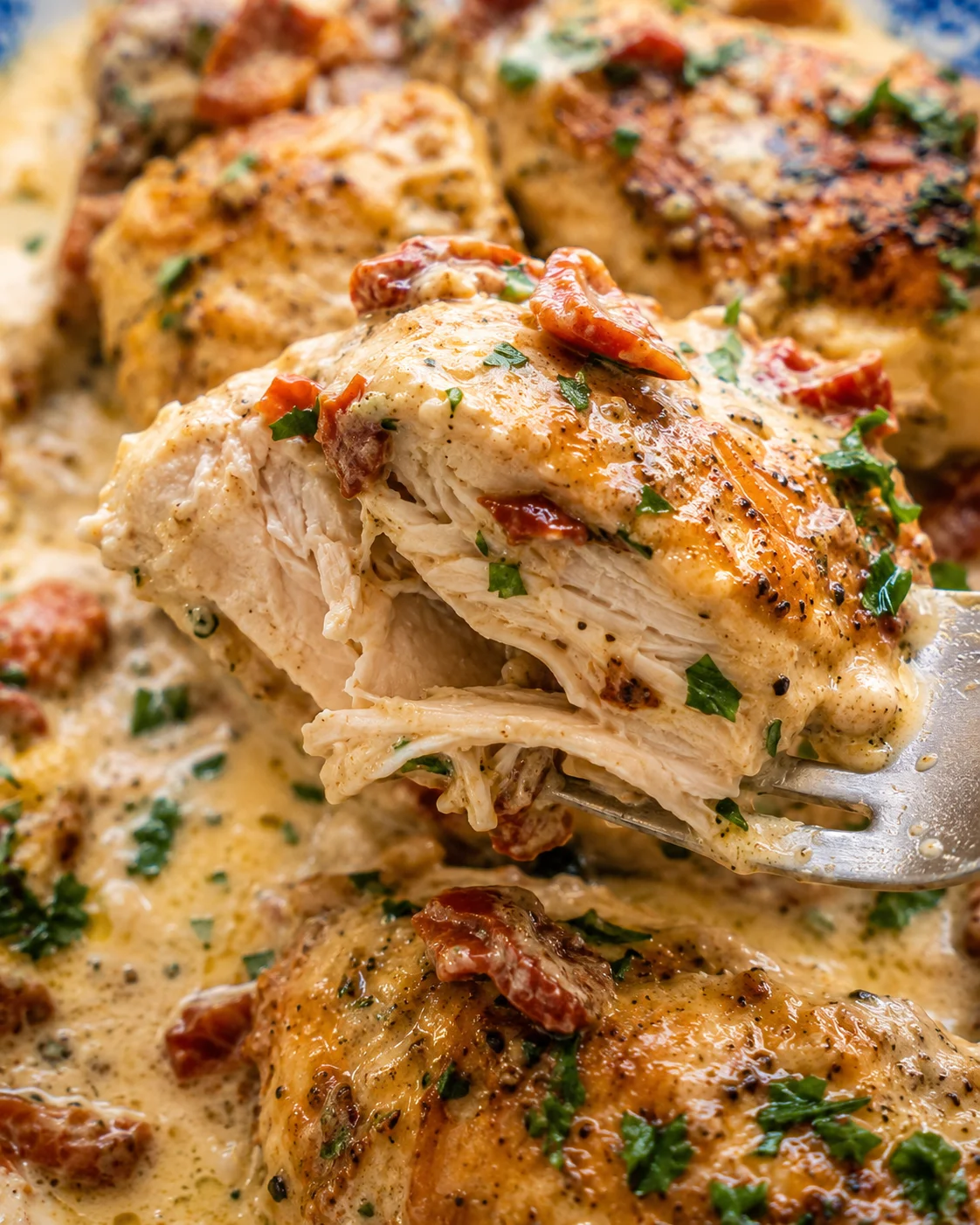 Fork lifting the tender shredded interior of Crock Pot Marry Me Chicken