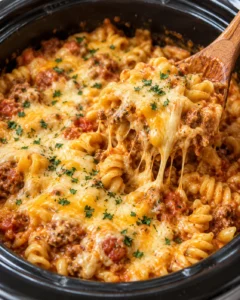Close-up of a hearty slow cooker pasta dish with glossy sauce and melted cheese
